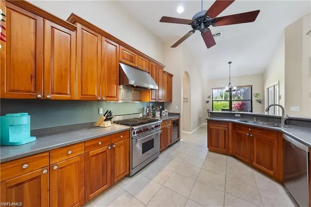 a kitchen with stainless steel appliances granite countertop a sink a stove and a refrigerator