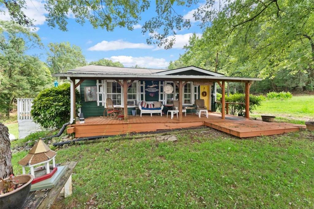 1542 Marlow Road Maysville, GA 30558 - Photo 4 of 35 a view of a patio with table and chairs potted plants and large tree