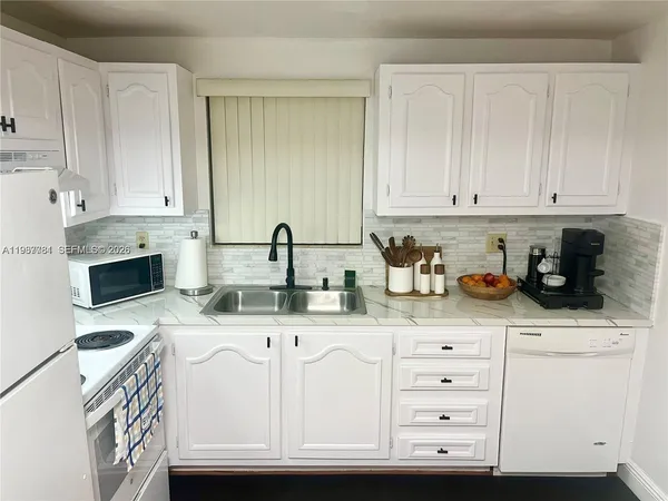 a kitchen with granite countertop a sink and cabinets
