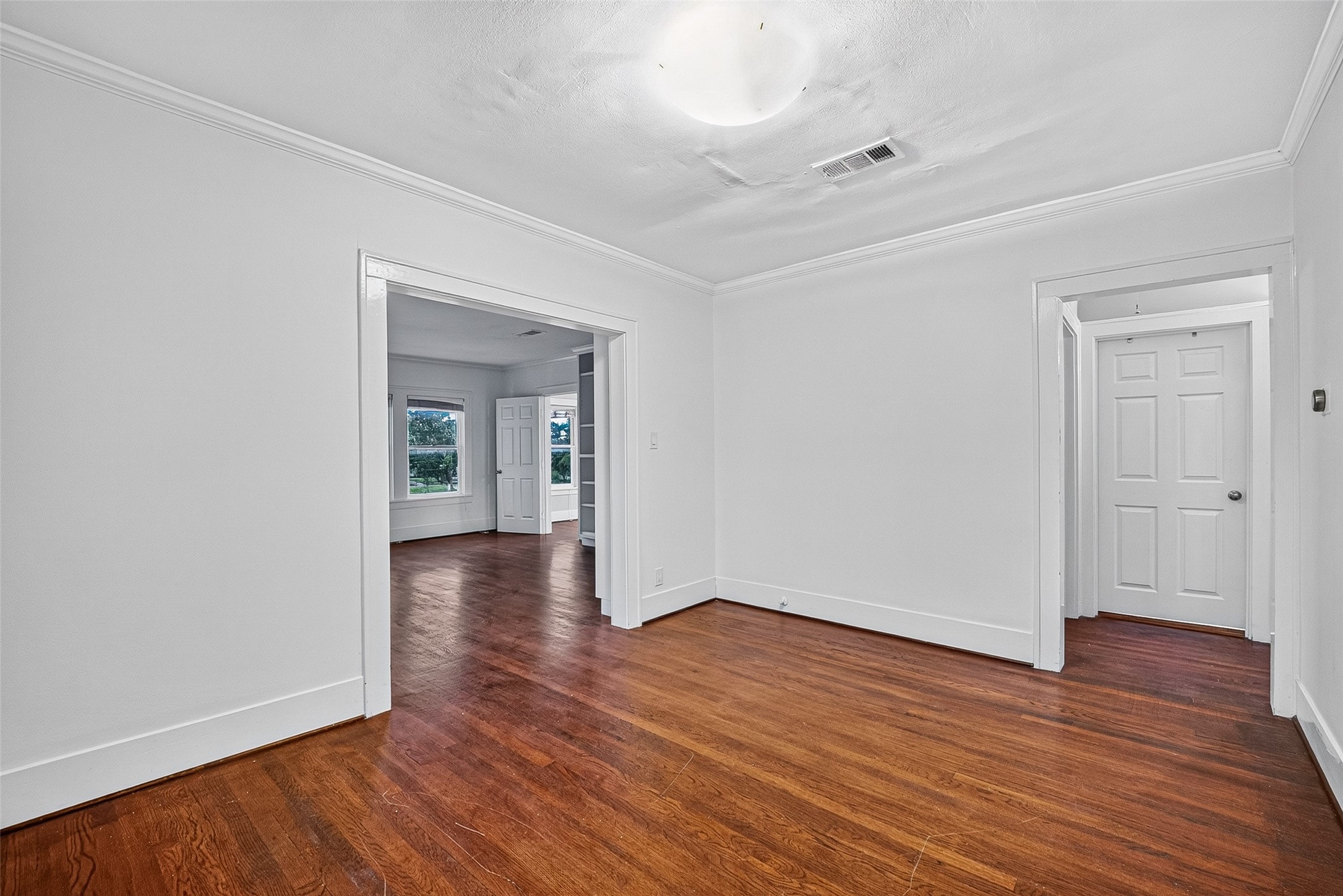 1758 Hawthorne Street, Unit 2 Houston, TX 77098 - Photo 15 of 19 Bright, open dining space with hardwood floors, neutral gray walls, and white trim. It features wide doorways leading to additional rooms and a visible bathroom with stylish tile work.