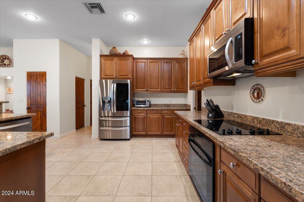 1706 West Parsons Road Phoenix, AZ 85085 - Photo 24 of 58 a kitchen with stainless steel appliances granite countertop a stove a sink and a refrigerator