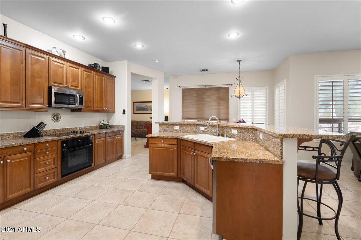 1706 West Parsons Road Phoenix, AZ 85085 - Photo 26 of 58 a large kitchen with stainless steel appliances granite countertop a stove a sink dishwasher a microwave oven and a refrigerator