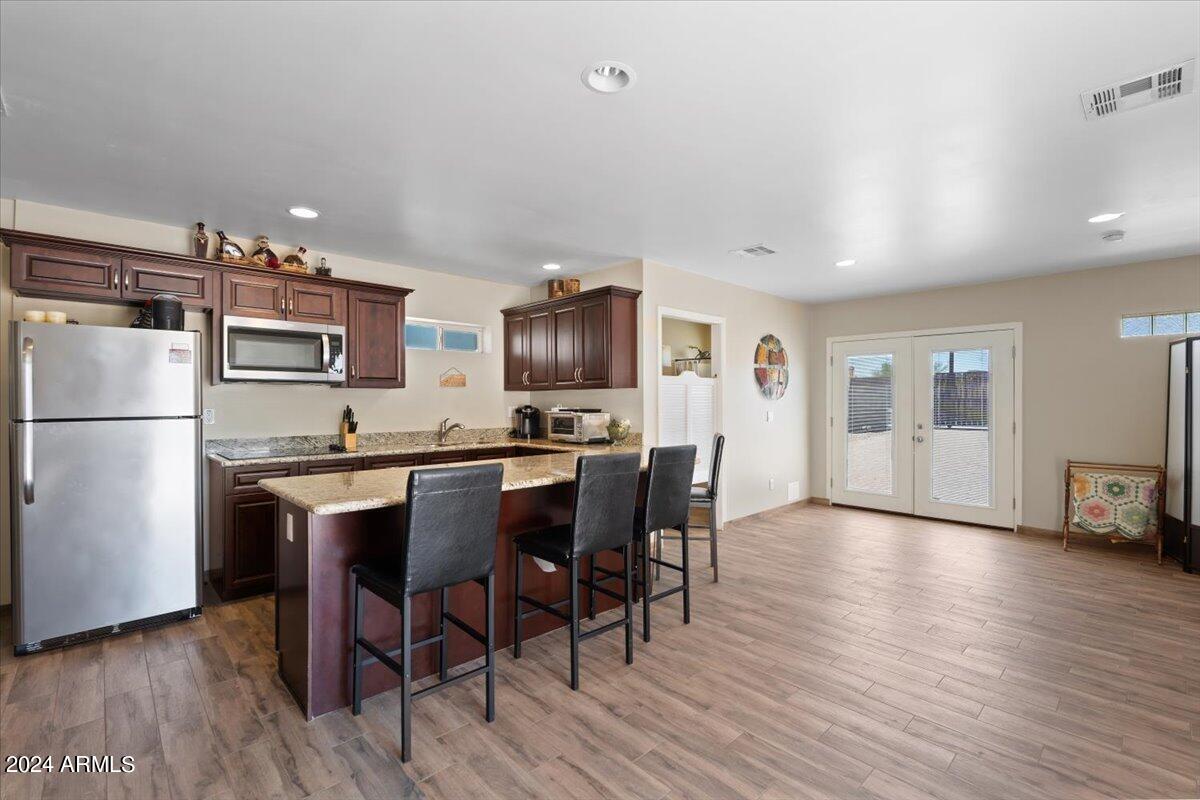 1706 West Parsons Road Phoenix, AZ 85085 - Photo 52 of 58 a kitchen with stainless steel appliances granite countertop a refrigerator a stove a microwave oven a sink a dining table and chairs with wooden floor