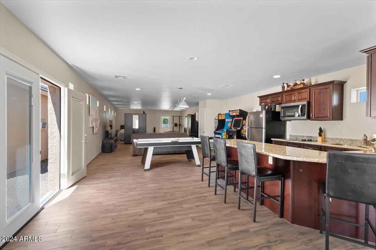 1706 West Parsons Road Phoenix, AZ 85085 - Photo 53 of 58 a dining hall with stainless steel appliances kitchen island granite countertop a dining table chairs and granite counter tops