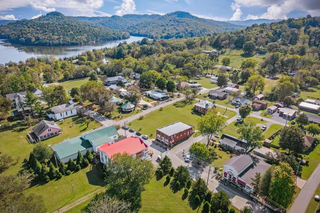 an aerial view of residential houses with outdoor space and river