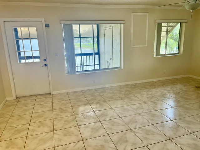 a view of a hallway with wooden floor and a bathroom
