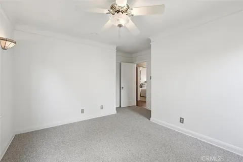 a view of an empty room with a chandelier fan