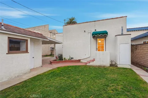 a backyard of a house with table and chairs