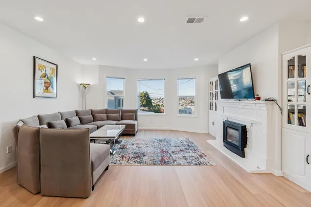 a living room with furniture a flat screen tv and a fireplace