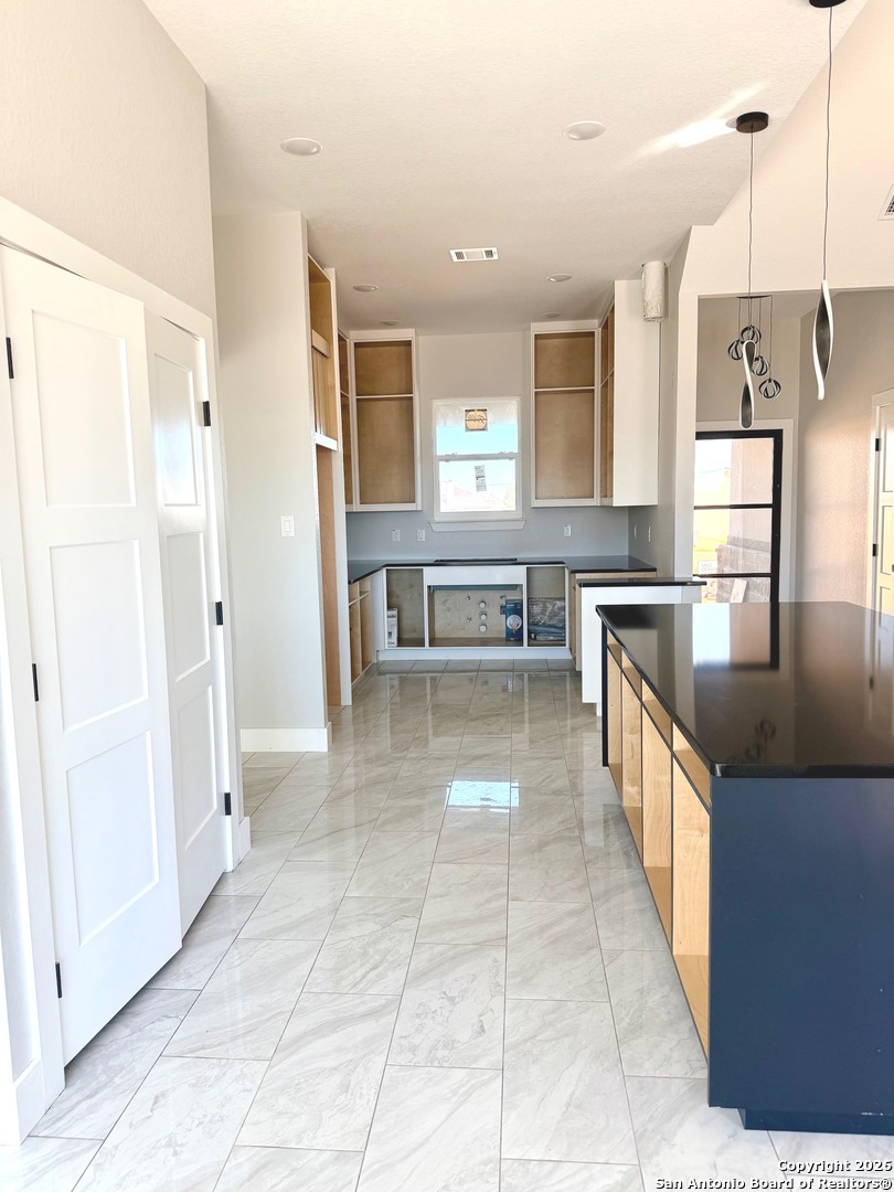 133 Merion Lane La Vernia, TX 78121 - Photo 6 of 18 a large kitchen with kitchen island granite countertop a large counter top and stainless steel appliances