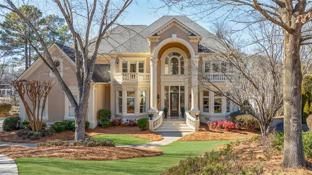 a front view of a house with yard and green space