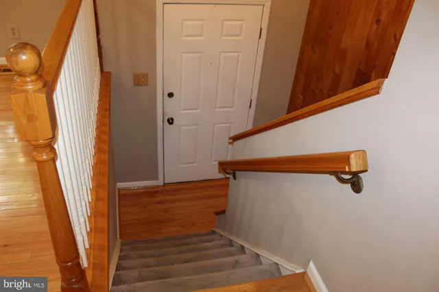 a view of a hallway with wooden floor and windows