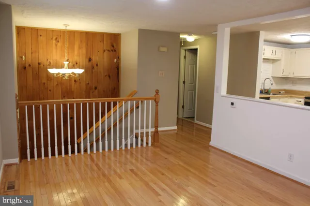 wooden floor in an empty room with a kitchen