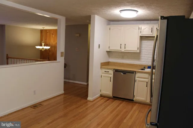 an empty room with wooden floor & closet area