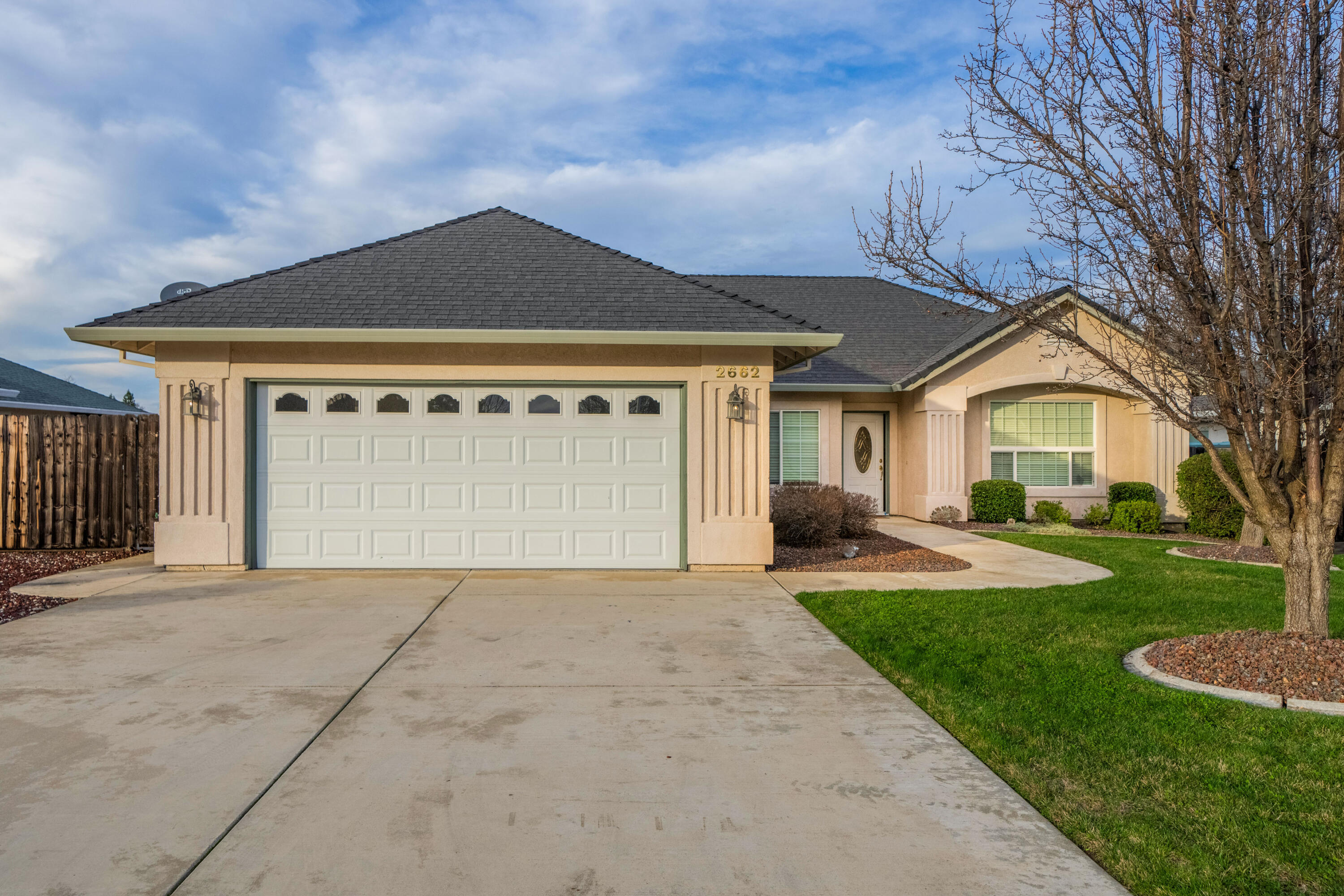 2662 Queens Way Redding, CA 96001 - Photo 1 of 21 a front view of a house with a yard and garage
