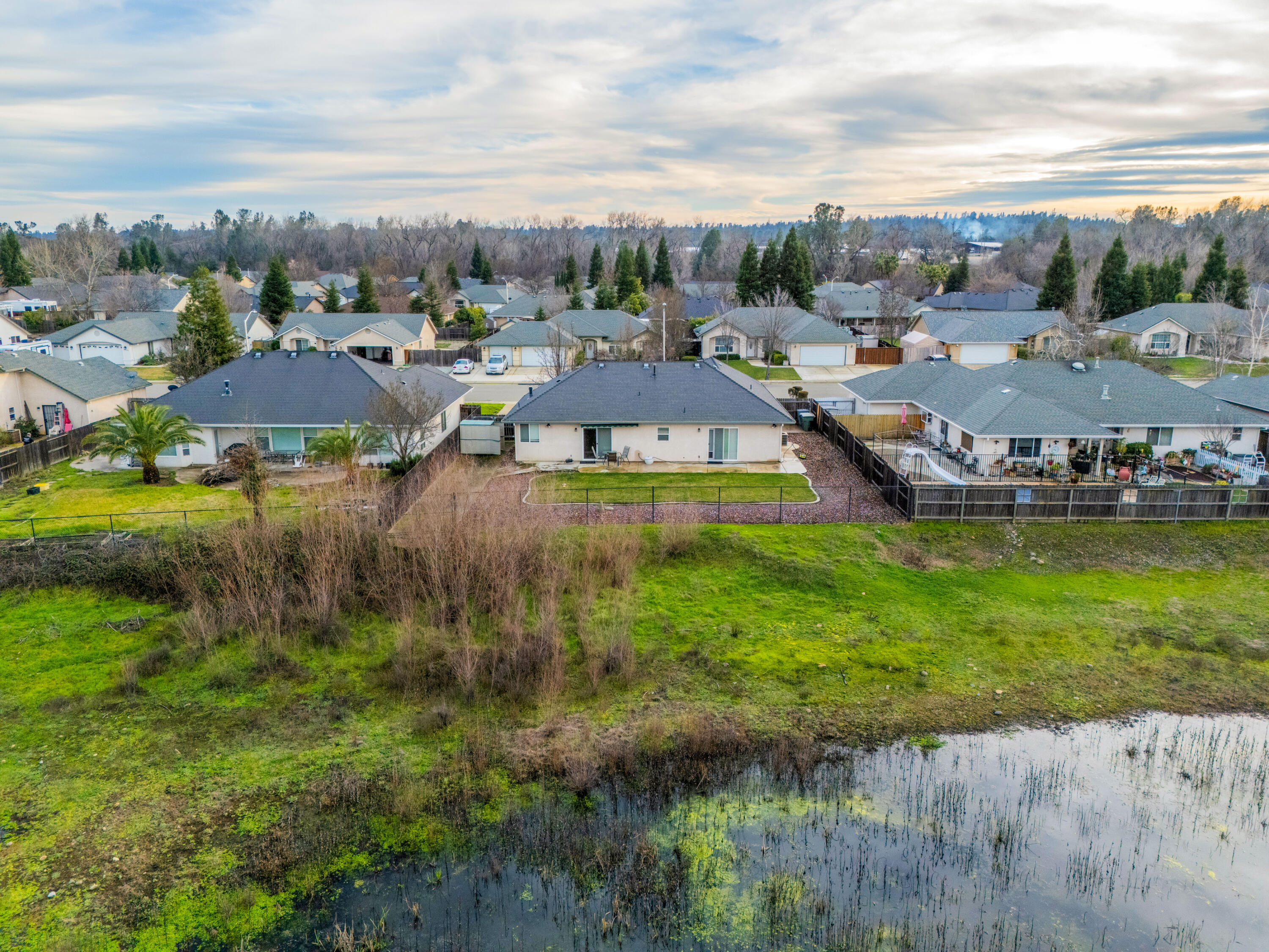 2662 Queens Way Redding, CA 96001 - Photo 17 of 21 a view of a lake with lawn chairs and large trees