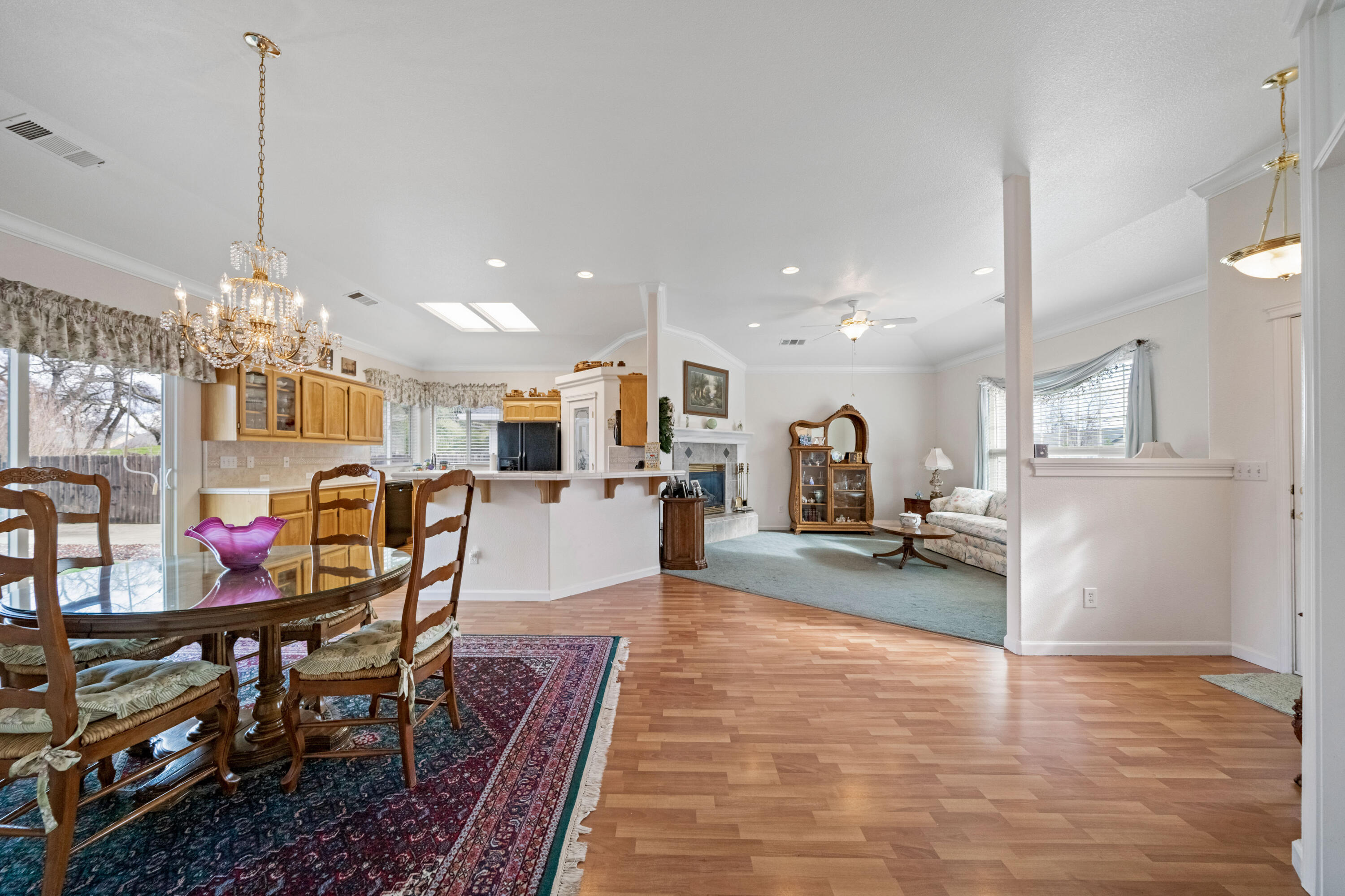 2662 Queens Way Redding, CA 96001 - Photo 5 of 21 a view of a dining room and livingroom with furniture wooden floor a chandelier