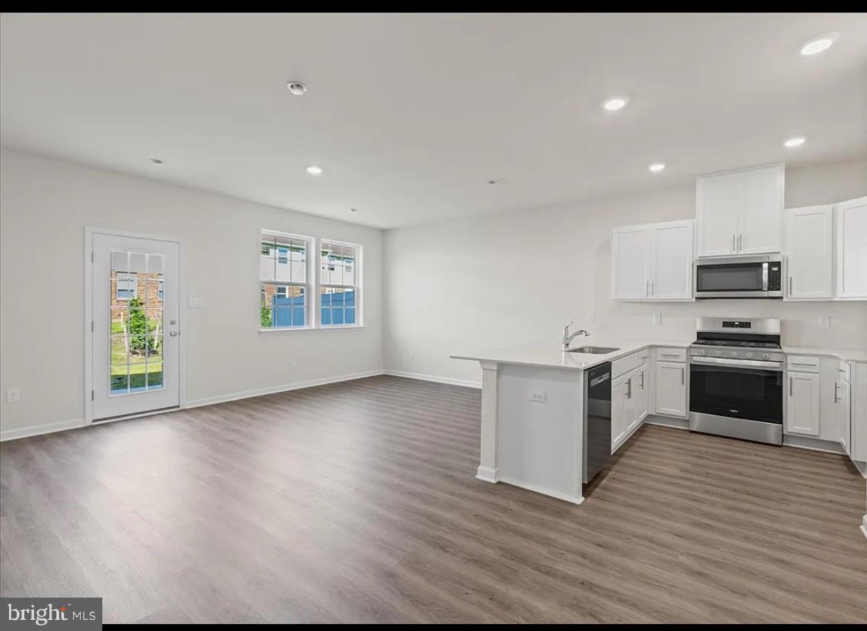 21 Whaler Drive Runnemede, NJ 08078 - Photo 5 of 20 a kitchen with wooden floors and white stainless steel appliances