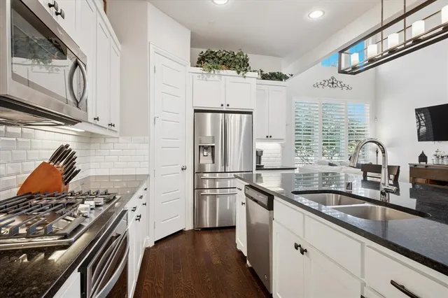 a kitchen with stainless steel appliances granite countertop a sink stove and refrigerator