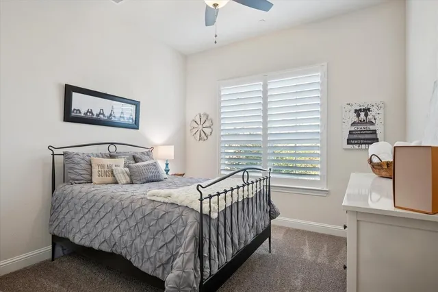 a bedroom with a bed and a window with chair