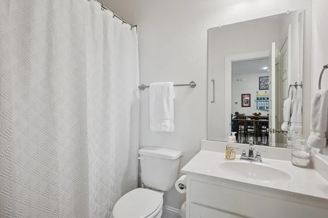 a bathroom with a sink a toilet and shower curtain