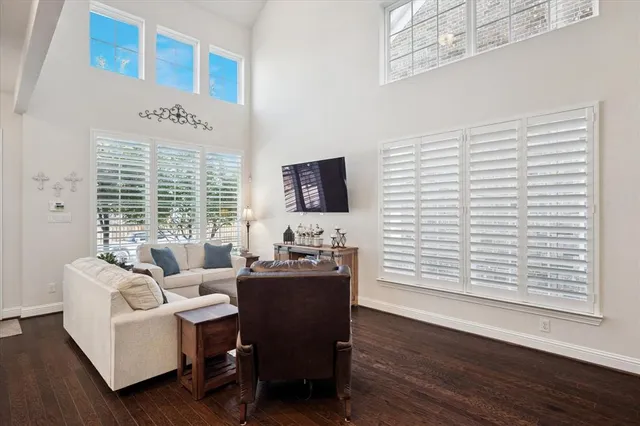 a living room with furniture floor to ceiling window and wooden floor