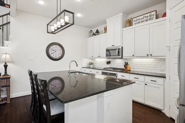 a kitchen with a stove a clock and cabinets