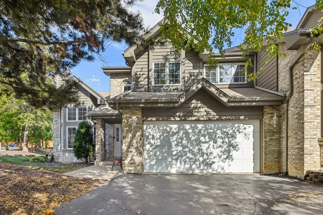 a front view of a house with a tree
