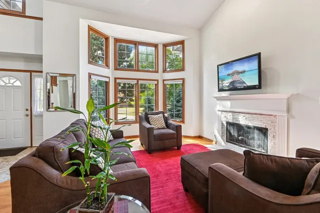 a living room with furniture a flat screen tv and a fireplace