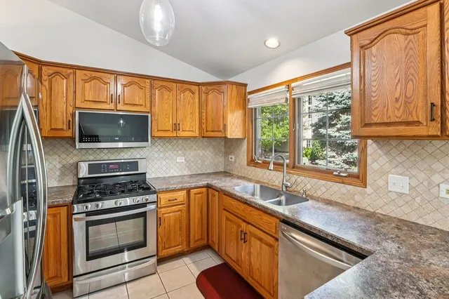 a kitchen with stainless steel appliances a stove sink and microwave