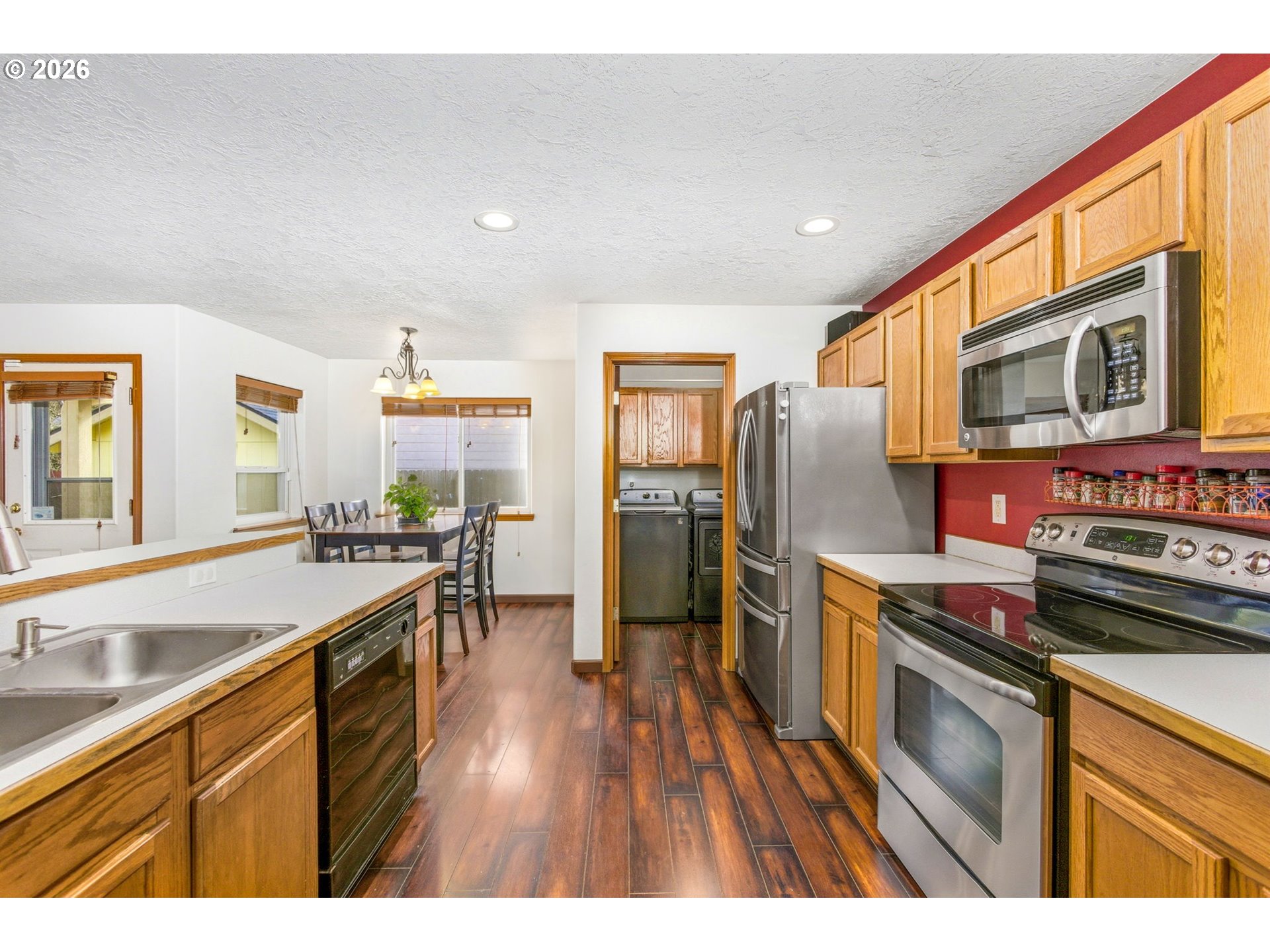 4820 Rebecca Street Northeast Salem, OR 97305 - Photo 12 of 30 a kitchen with stainless steel appliances granite countertop a stove top oven a sink dishwasher a refrigerator and a dining table with wooden floor