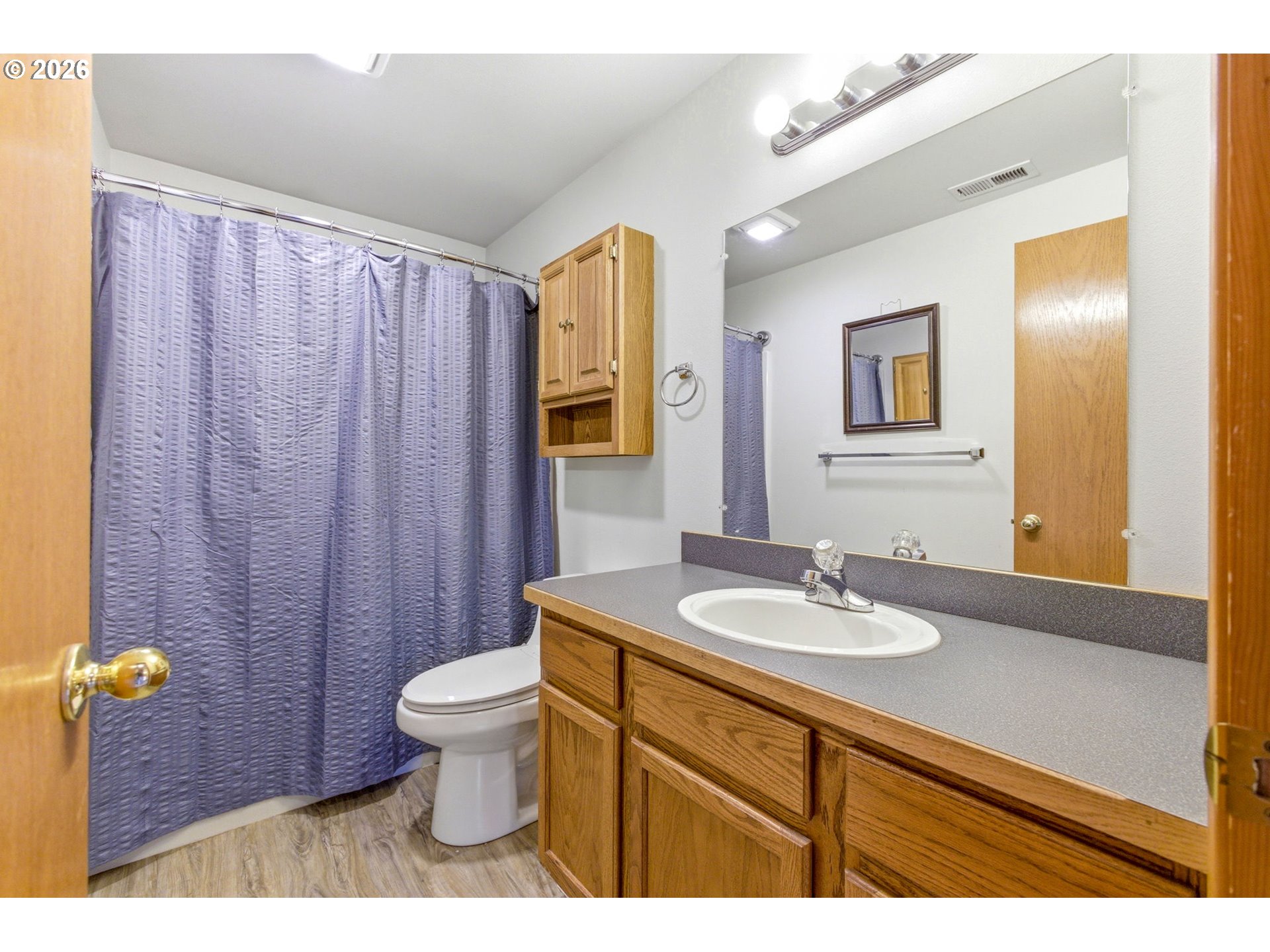4820 Rebecca Street Northeast Salem, OR 97305 - Photo 20 of 30 a bathroom with a granite countertop sink a toilet a mirror and shower curtain