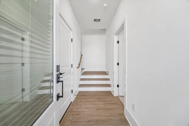 a view of a hallway with wooden floor and staircase