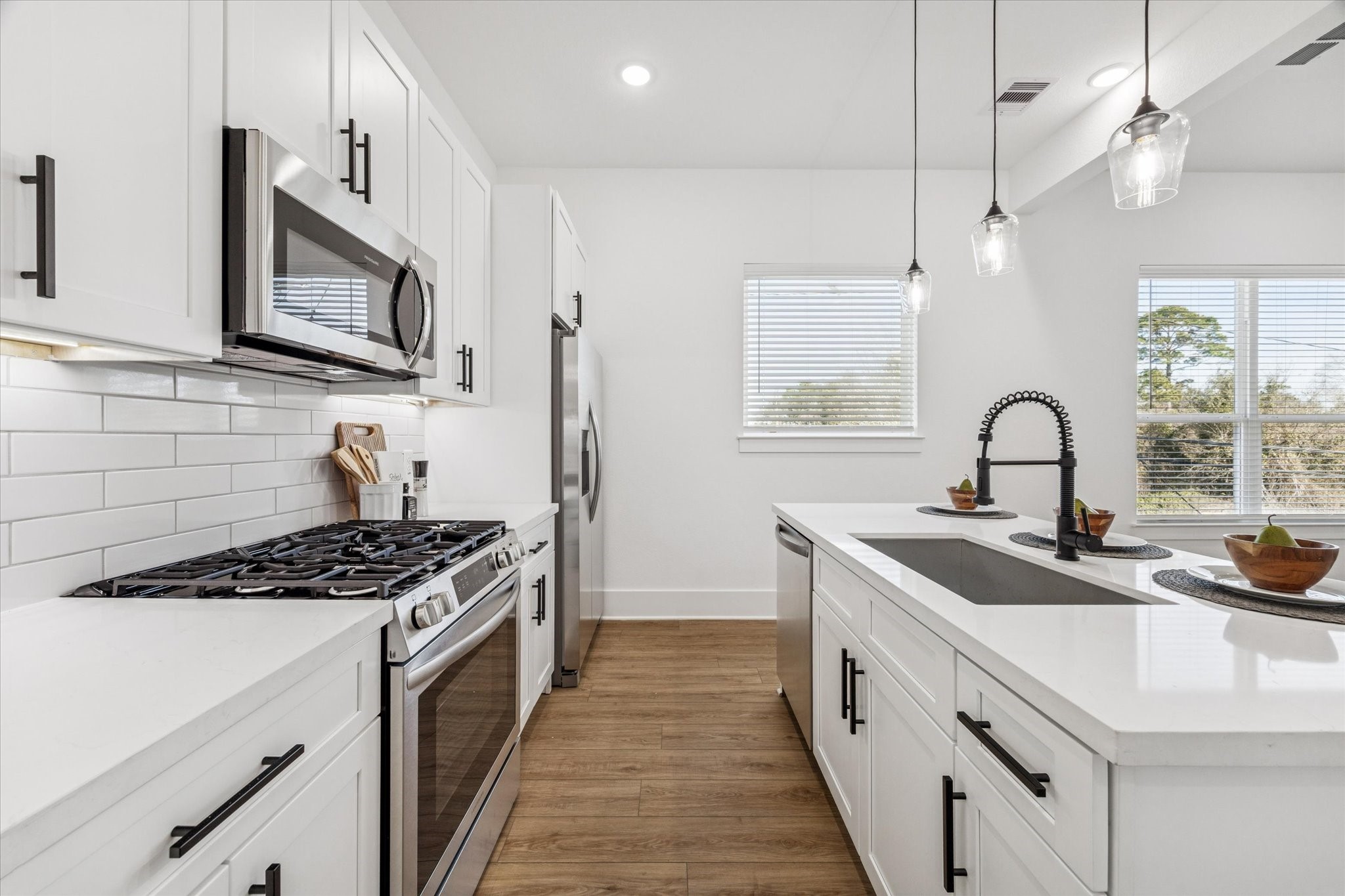 5627 Azores Houston, TX 77091 - Photo 22 of 38 a kitchen with stainless steel appliances a sink a stove and cabinets