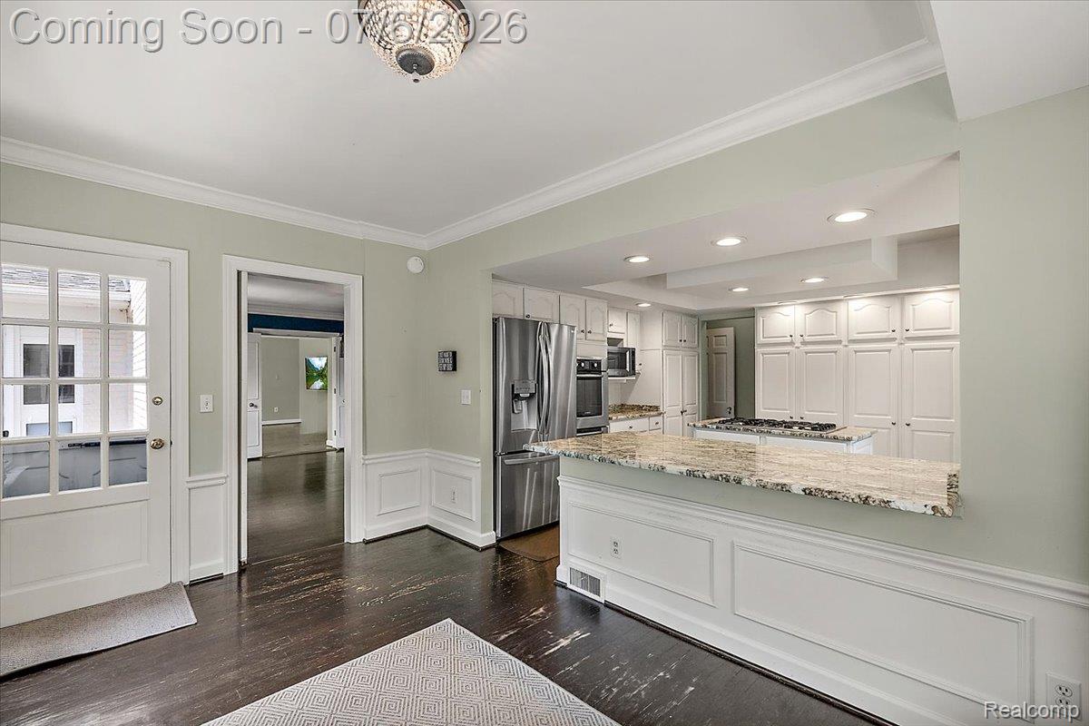 1051 Devonshire Road Grosse Pointe, MI 48230 - Photo 7 of 98 Open-concept kitchen with white cabinetry, stainless steel appliances, recessed lighting, and a stone countertop peninsula