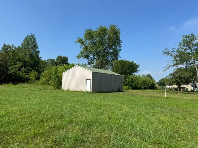 a backyard of a house with plants and large trees