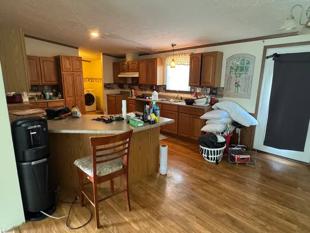a kitchen with a table chairs refrigerator and microwave