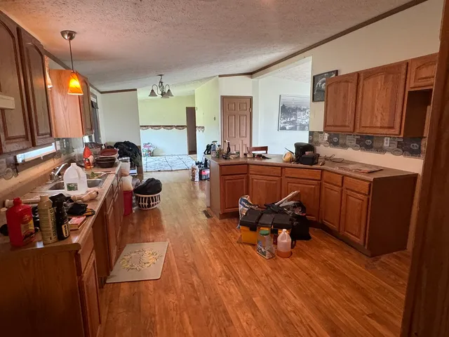 a living room with furniture a large window and wooden floors