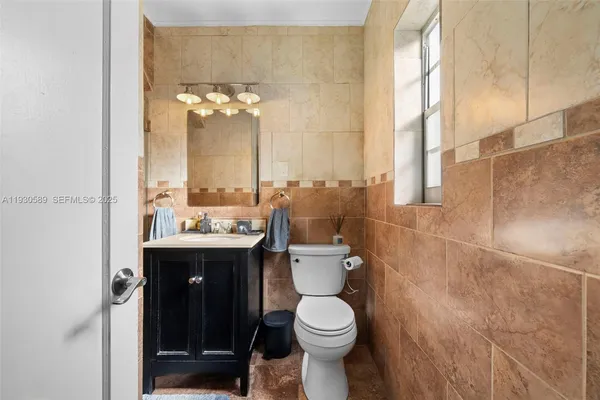 a bathroom with a sink vanity mirror and toilet