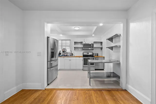 a kitchen with white cabinets and stainless steel appliances