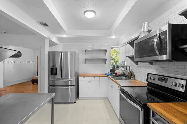 a kitchen with stainless steel appliances a stove a sink and a refrigerator
