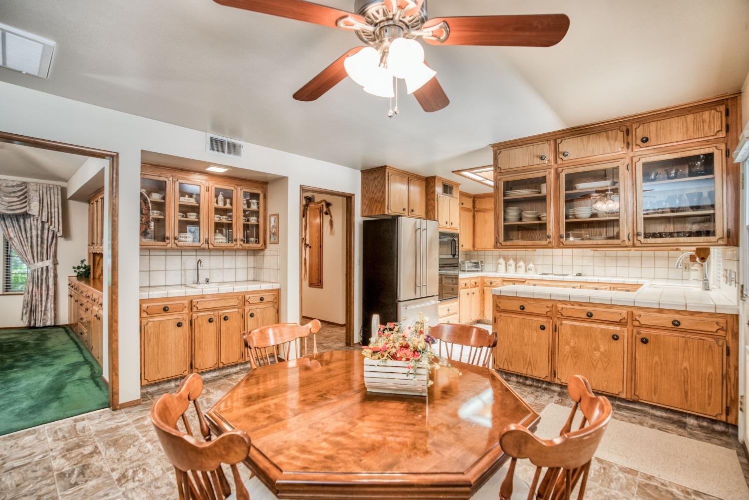 77 Post Avenue Sanger, CA 93657 - Photo 21 of 62 a kitchen with stainless steel appliances kitchen island granite countertop a table chairs in it and wooden floors
