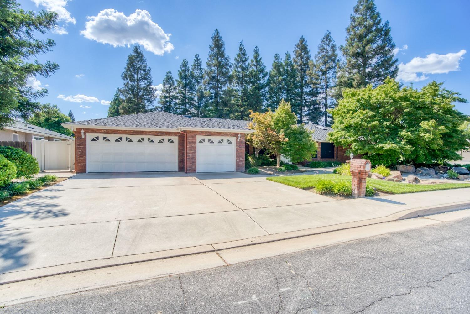 77 Post Avenue Sanger, CA 93657 - Photo 28 of 62 a view of yellow house with a yard and potted plants