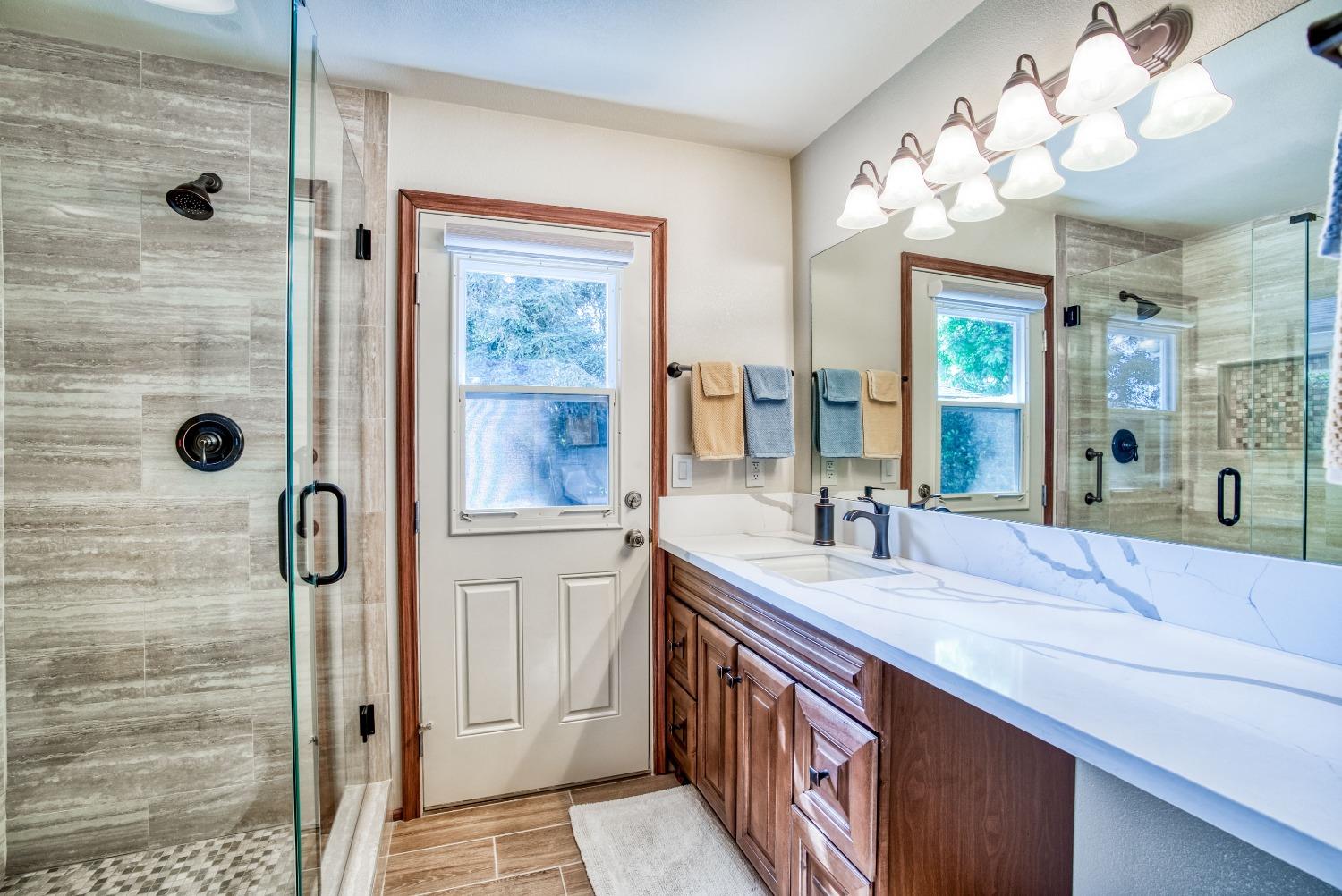 77 Post Avenue Sanger, CA 93657 - Photo 41 of 62 a bathroom with a granite countertop sink mirror and shower