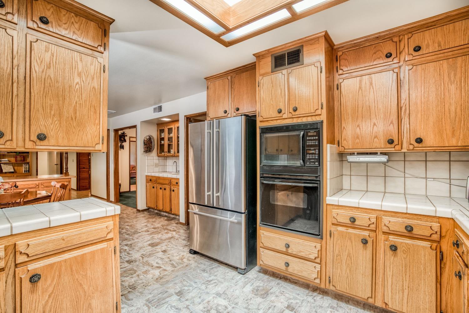 77 Post Avenue Sanger, CA 93657 - Photo 8 of 62 a kitchen with stainless steel appliances granite countertop a refrigerator and a stove top oven