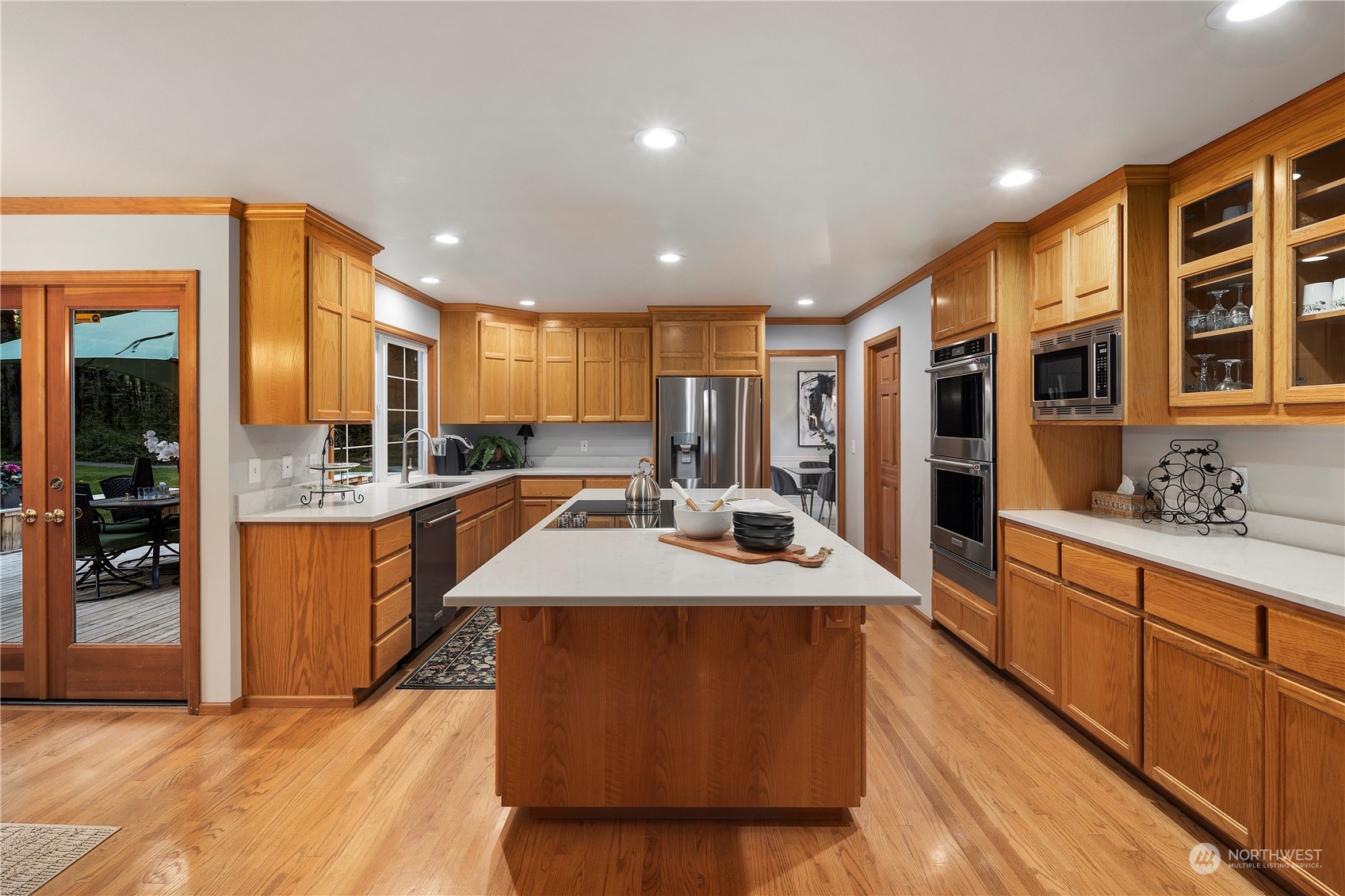 5381 242nd Place Northeast Redmond, WA 98053 - Photo 11 of 40 a large kitchen with kitchen island a sink a stove and a refrigerator with wooden floor