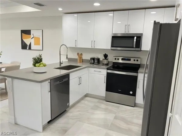 a kitchen with stainless steel appliances granite countertop a stove a sink and a microwave