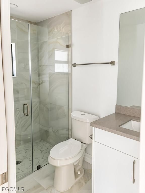 4854 30th Street Southwest Lehigh Acres, FL 33973 - Photo 6 of 11 a white toilet sitting next to a bathroom sink