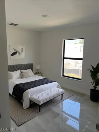 a bedroom with a bed lamp and a potted plant