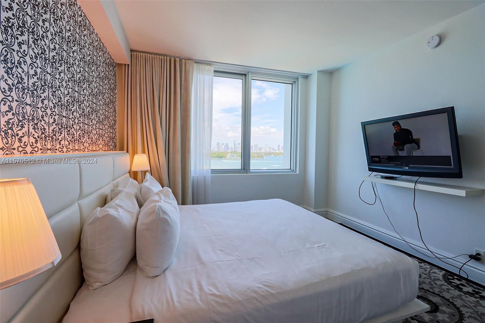1100 West Avenue, Unit 816 Miami Beach, FL 33139 - Photo 11 of 22 a bedroom with a bed and a flat screen tv